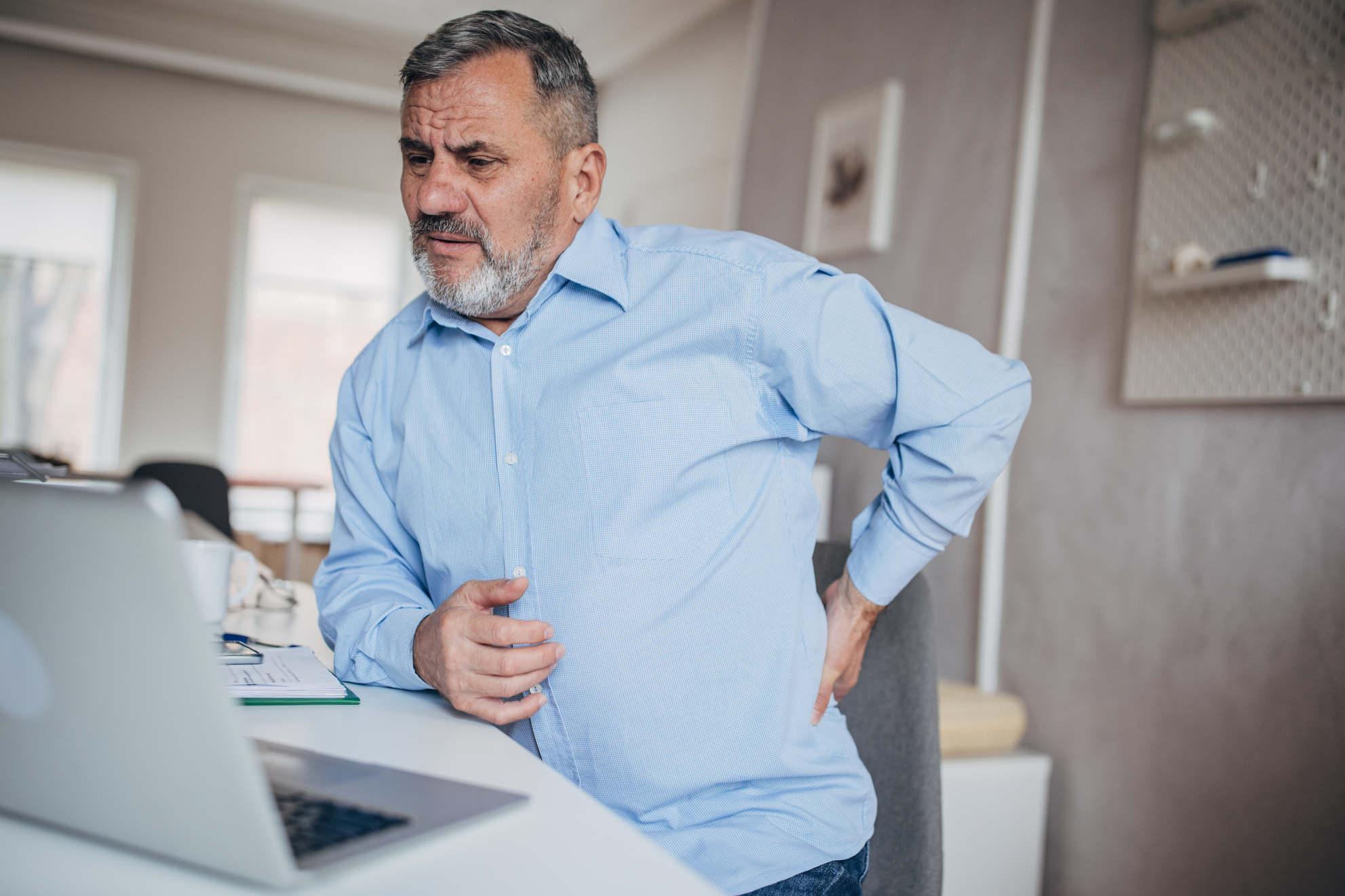 Man With Chronic Back Pain When Sitting At His Desk