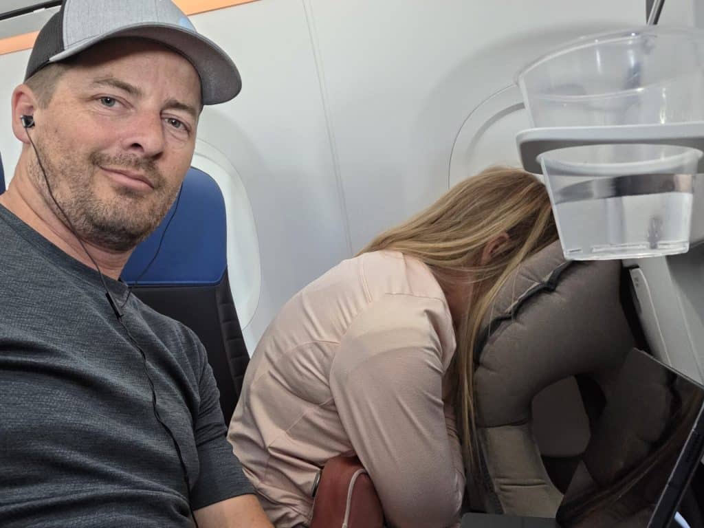 In this photo, David Butler and his wife showcase practical strategies for managing back pain during air travel.